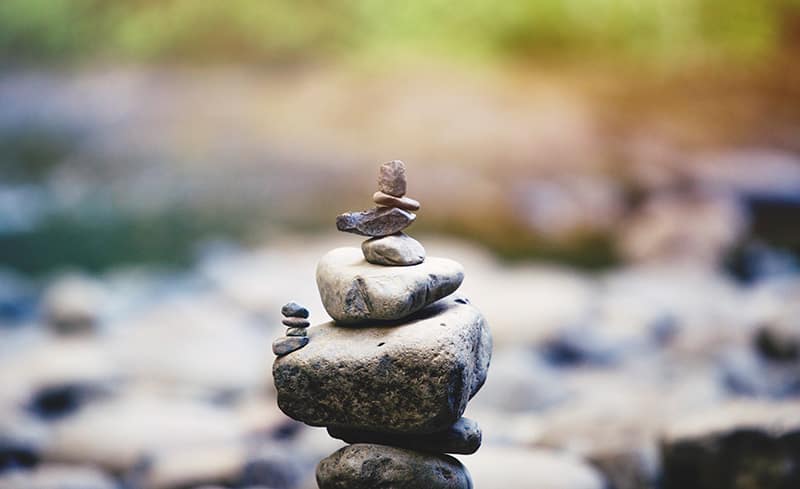 rocks stacked in river - stress hypnosis guide
